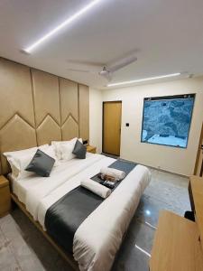 a bedroom with a large bed with a large screen at Hotel sun town in Ahmedabad