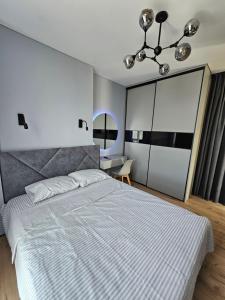 Un dormitorio con una gran cama blanca y un escritorio. en Яровиця 41, en Lutsk