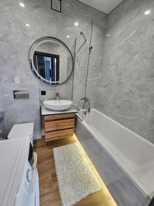 Un baño con lavabo, bañera y espejo. en Яровиця 41, en Lutsk