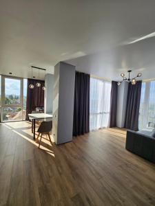 Una gran sala de estar con una mesa y un sofá. en Яровиця 41, en Lutsk