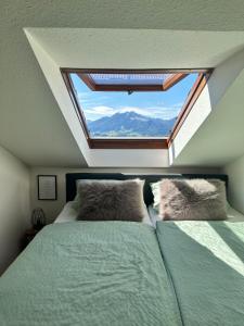 Cette chambre comprend deux lits et une grande fenêtre. dans l'établissement FeWo Alpenherz im Allgäu, mit Balkon und Bergblick, à Rettenberg