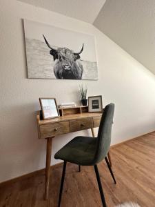 un bureau avec une photo d'un taureau sur le mur dans l'établissement FeWo Alpenherz im Allgäu, mit Balkon und Bergblick, à Rettenberg
