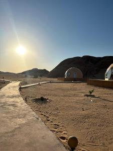 a view of a desert with tents in the background at Milky Way Luxury Camp in Wadi Rum +4 photos