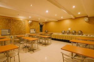 a restaurant with tables and chairs and a counter at Hotel Perfect, Karol Bagh, 2 mins walk from metro station in New Delhi