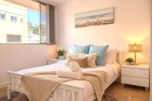 una camera da letto con un letto e un asciugamano sopra di 2 BR Burleigh Beach Family Apartment a Gold Coast
