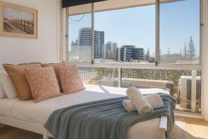 una camera da letto con un letto e una grande finestra di 2 BR Burleigh Beach Family Apartment a Gold Coast