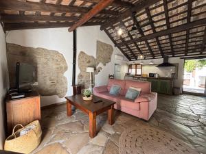 a living room with a pink couch and a tv at La casa vieja de Marchenilla in Jimena de la Frontera