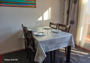 a dining room table with a white table cloth on it at Le 503, Apt 2 pcs 4 pers, piscine, proche centre in Grasse