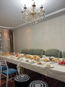 a long table with plates of food on it at Guest House Kaiyndy in Kaindy