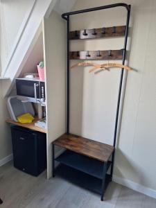 a shelf under the stairs with a bench in a room at 22up Bed & Koffie in Den Burg