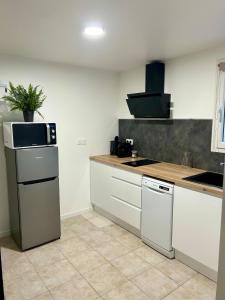 una cucina con armadi bianchi e una pianta sul bancone di Quiet cozy apartment, air conditioning, swimming pool a Vidauban