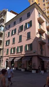 a pink building with people walking in front of it at Nest Rest in La Spezia