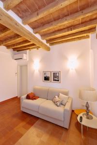 un divano bianco in un soggiorno con soffitti in legno di Casa Lippa a Spilamberto