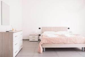a white bedroom with a bed and a dresser at Micky House in San Marzano sul Sarno +3 photos