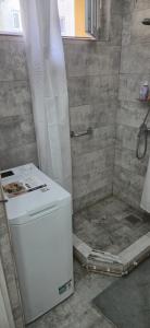 a shower with a white refrigerator in a bathroom at LCB Apartments C04 in Târgu-Mureş