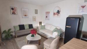 a living room with a couch and a refrigerator at Appartement golf saumane Celomidie in Saumane-de-Vaucluse