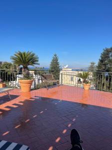 a person is sitting on a patio with plants at La Terrazza Quisisana Sorrento Coast in Castellammare di Stabia