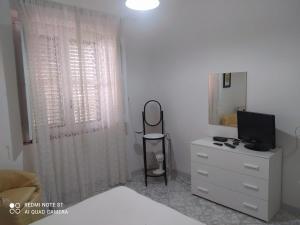 a bedroom with a bed and a dresser with a television at PM 698 Via Fuscillo in Mattine