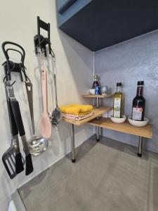 a kitchen with a shelf with cooking utensils and bottles at Tranquille Maisonnette entre Vincennes et St Mandé in Montreuil
