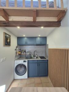 a kitchen with a washing machine and a sink at Tranquille Maisonnette entre Vincennes et St Mandé in Montreuil