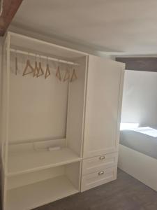 a white cabinet with hangers in a bedroom at Tranquille Maisonnette entre Vincennes et St Mandé in Montreuil +10 photos