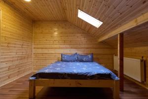 a bed in a wooden room with a wooden ceiling at Cabana Valea Lui Bogdan in Coada Izvorului