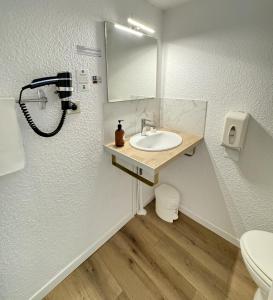 a bathroom with a sink and a mirror at Couett'Hôtel Brest Port de plaisance, Les pieds dans l'eau in Brest