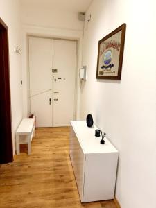 a white room with a white table and a chair at Casa Monticello 1 in Trieste +3 photos