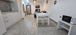 a kitchen and dining room with a table and a tv at Azizi Apartment Beach Pool & Spa Resort in Mamaia Nord