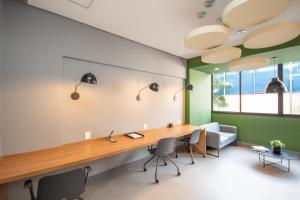 an office with a long desk with chairs and lamps at Maison Perdizes - Allianz Parque Supreme in Sao Paulo