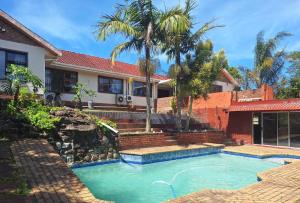 a swimming pool in front of a house at Home in Beacon Bay in East London