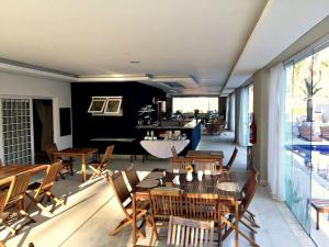 a restaurant with wooden tables and chairs and a room at Hotel Granja Brasil Resort in Itaipava