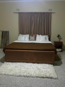 a large bed in a bedroom with a window at MableHomestay in Mzuzu