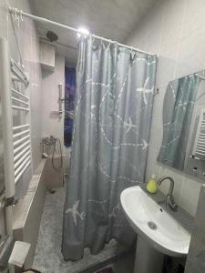 a bathroom with a shower curtain with sharks on it at Pariss Library Hostel in Yerevan +13 photos
