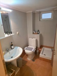 a bathroom with a white toilet and a sink at Mavi Stay in Alexandroupoli +21 photos