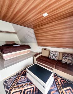 Kejajarにあるaf house villa and cabinのベッドとソファのある小さな部屋