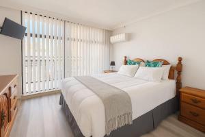 Un dormitorio con una cama grande y una ventana grande. en 1BR Apartment Heated pool, en Gold Coast