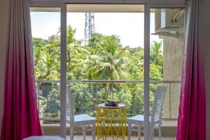 a room with a window with two chairs and a table at White Pearl by Leo Homes - 2BHK near Anjuna Beach in Anjuna