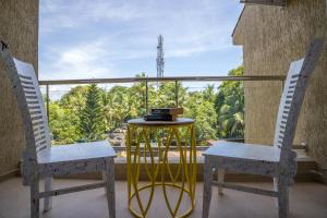 two chairs and a table on a balcony with a view at White Pearl by Leo Homes - 2BHK near Anjuna Beach in Anjuna