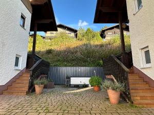 a patio with a bench and stairs next to a building at Modernes Top Apartment mitten im Bayerischen Wald + WLAN kostenfrei in Schöfweg