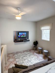 a living room with a flat screen tv on a wall at Apartamento no centro de Aparecida in Aparecida +41 photos
