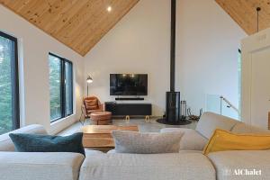 een woonkamer met twee banken en een flatscreen-tv bij Oslo Scandinavian Getaway Spa & Pet-Friendly in Saint Come