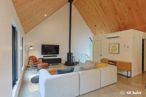 een woonkamer met een witte bank en een tv bij Oslo Scandinavian Getaway Spa & Pet-Friendly in Saint Come +40 foto's