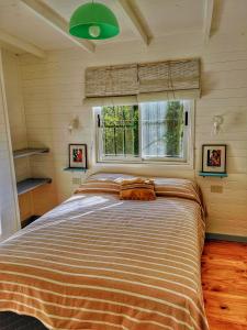 a large bed in a bedroom with a window at Cabaña - Jazmín in Tigre