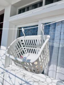 a white basket hanging on a window sill at Two-bedroom apartment - Spacious, with a gym and well-equipped in Beira