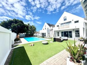 a backyard with a dog laying on the grass at Adrift Guesthouse in St Francis Bay
