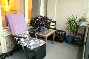 a porch with a chair and a table with a plant at En charmig etta in Visby
