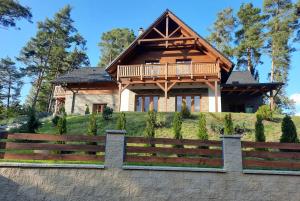 una casa de madera con una valla delante en Villa Viktoria, en Hamr na Jezeře