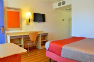 a hotel room with a bed and a desk with a television at Motel 6 - Santa Nella, on i-5 in Santa Nella +58 photos