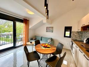 a kitchen and living room with a table and chairs at Harmony Garden Apartments in Kotor